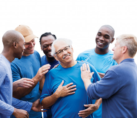 group of men supporting one man smiling