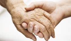 one hand holds the other elderly hand